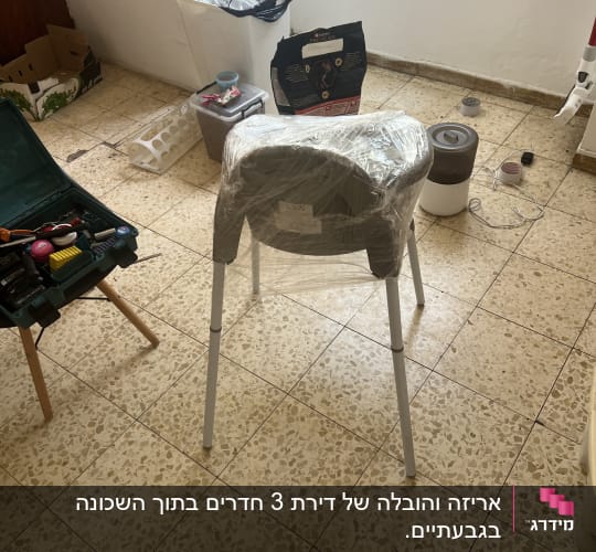 חדר עם כיסא עטוף בניילון וכלי עבודה